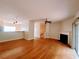 Open living space with hardwood floors, ceiling fan, fireplace and views into dining area and staircase at 523 Lantern Wood Dr, Scottdale, GA 30079