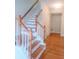 Bright foyer with classic wooden staircase and hardwood floors, creating a welcoming entrance to the home at 523 Lantern Wood Dr, Scottdale, GA 30079
