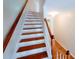 Wooden staircase ascends toward a sunlit landing, offering an open and airy feel throughout the home at 523 Lantern Wood Dr, Scottdale, GA 30079