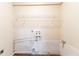 A compact unfinished laundry room features white brick and an overhead wire rack at 2062 Whites Mill Rd, Decatur, GA 30032