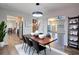 Open-concept dining room featuring stylish light fixture, wood floors, and adjacent kitchen and living areas at 2228 Arbor Forest Sw Trl, Marietta, GA 30064