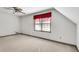 This bedroom features neutral walls and carpet, a ceiling fan, and window dressed with a red valance at 3189 Terramar Dr, Atlanta, GA 30341
