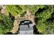 Aerial view of a home with a putting green and a deck surrounded by mature trees at 320 N Drew Ct, Duluth, GA 30097