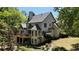 Stately home featuring a wooden deck, lower-level patio, and a putting green set amidst mature trees at 320 N Drew Ct, Duluth, GA 30097