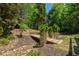 Backyard landscape featuring decorative bridge surrounded by mature trees and manicured lawn at 320 N Drew Ct, Duluth, GA 30097