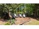 Inviting backyard with mature trees, Adirondack chairs, and a wooden fence for privacy at 320 N Drew Ct, Duluth, GA 30097