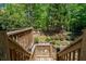 Backyard with stairs leading down to a grassy area with a playground, chairs, and trees at 320 N Drew Ct, Duluth, GA 30097