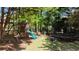 The backyard features a playground with a slide and a trampoline surrounded by lush greenery at 320 N Drew Ct, Duluth, GA 30097