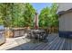 Outdoor deck with table, chairs, an umbrella, and a grill, surrounded by green trees at 320 N Drew Ct, Duluth, GA 30097