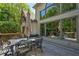 Wide planked deck with outdoor table and seating, and large windows reflecting the wooded backyard at 320 N Drew Ct, Duluth, GA 30097