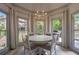 Bright breakfast nook with a chandelier and beautiful views of the surrounding greenery through multiple windows at 320 N Drew Ct, Duluth, GA 30097