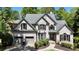 Attractive two-story traditional home with brick exterior, attached two-car garage, and mature trees at 320 N Drew Ct, Duluth, GA 30097