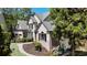Two-story traditional home with lush landscaping, a curved walkway, and a charming brick facade with accent siding at 320 N Drew Ct, Duluth, GA 30097