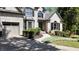 Charming home with a well-manicured lawn, a side-entry garage, and a brick exterior with black window shutters at 320 N Drew Ct, Duluth, GA 30097