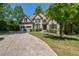 Traditional brick home boasts a long driveway, two car garage and manicured landscaping at 320 N Drew Ct, Duluth, GA 30097