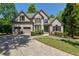 Charming two-story brick home with well-manicured front yard, a driveway, and attached two-car garage at 320 N Drew Ct, Duluth, GA 30097