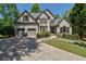Charming two-story brick home with manicured front yard, driveway, and attached two-car garage at 320 N Drew Ct, Duluth, GA 30097