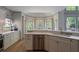 Open kitchen with stainless steel dishwasher, marble countertops and view to the breakfast area at 320 N Drew Ct, Duluth, GA 30097