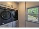 Well-organized laundry room with modern washer and dryer, cabinetry, and a window at 320 N Drew Ct, Duluth, GA 30097