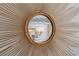 Close up of sunburst mirror with rope trim, reflecting a chandelier at 320 N Drew Ct, Duluth, GA 30097