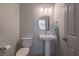 Elegant powder room with a pedestal sink, round mirror, and modern lighting at 320 N Drew Ct, Duluth, GA 30097