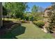 Backyard putting green surrounded by stone accents and lush landscaping, perfect for golf enthusiasts at 320 N Drew Ct, Duluth, GA 30097