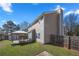 View of a backyard with grass, wooden fence, shed, and shaded patio at 401 Windstream Sw Dr, Marietta, GA 30060