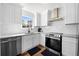 Charming kitchen boasts stainless steel appliances, white cabinets, and modern finishes at 401 Windstream Sw Dr, Marietta, GA 30060