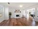 Bright living room featuring a white brick fireplace, modern lighting, and wood flooring at 401 Windstream Sw Dr, Marietta, GA 30060