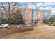 Exterior view of brick building with gated entrance and manicured lawn and surface parking at 130 26Th Nw St # 807, Atlanta, GA 30309