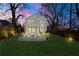 Stunning backyard with a modern patio, lush lawn, privacy fence, and elegant lighting for evening enjoyment at 1604 Temple Ave, Atlanta, GA 30337