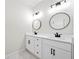 Bathroom featuring a double vanity with black fixtures and a round mirror at 1604 Temple Ave, Atlanta, GA 30337