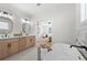 Bright bathroom featuring double sinks, a soaking tub, and an entry to a stylish bedroom at 1604 Temple Ave, Atlanta, GA 30337