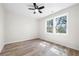 A bright bedroom featuring wood flooring, a ceiling fan, and a double window letting in natural light at 1604 Temple Ave, Atlanta, GA 30337