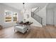Dining area with modern light fixture and natural light; features wood floors and stairway at 1604 Temple Ave, Atlanta, GA 30337