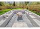 Unique sunken fire pit area with built-in seating and gravel flooring, creating a stylish outdoor gathering space at 1604 Temple Ave, Atlanta, GA 30337