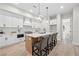 Bright kitchen features white cabinets, marble backsplash, a kitchen island with seating, and stainless steel appliances at 1604 Temple Ave, Atlanta, GA 30337