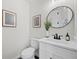 Stylish powder room featuring a white vanity with marble countertop and modern fixtures at 1604 Temple Ave, Atlanta, GA 30337