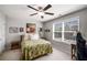 This bedroom features a ceiling fan, floral bedding, and is illuminated with lots of natural light at 2910 Bishopstone Way, Cumming, GA 30040