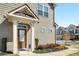 Inviting front entrance with a classic brown door, surrounded by lush landscaping and manicured bushes at 2910 Bishopstone Way, Cumming, GA 30040