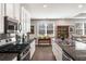 Eat-in kitchen and living room features stainless appliances, granite counters, and an open floor plan at 2910 Bishopstone Way, Cumming, GA 30040