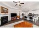 Open concept living room boasts a fireplace, mounted television, and island seating at the kitchen counter at 2910 Bishopstone Way, Cumming, GA 30040