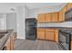 Galley kitchen with oak cabinets, black appliances and a grey countertop at 4571 Parkway Cir, Atlanta, GA 30349