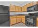 Kitchen features oak cabinets, dark countertops and black appliances at 4571 Parkway Cir, Atlanta, GA 30349