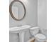 Powder room featuring a pedestal sink, round mirror and a toilet at 4571 Parkway Cir, Atlanta, GA 30349