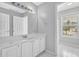 Bright bathroom featuring a single vanity, a large mirror, and a window offering an exterior view at 617 Creekstone Ct, Jonesboro, GA 30236