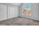 Bedroom boasts natural light from a large arched window, paired with neutral walls and carpet at 617 Creekstone Ct, Jonesboro, GA 30236