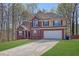 Traditional two-story brick home with an attached two-car garage and well-maintained lawn at 617 Creekstone Ct, Jonesboro, GA 30236