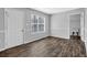 Spacious room with wood floors, neutral walls, a window, and an entryway at 617 Creekstone Ct, Jonesboro, GA 30236