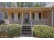 Inviting front porch with a classic door, and well-manicured shrubbery at 8633 Hilltop Rd, Jonesboro, GA 30236